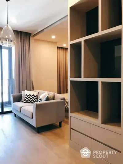 Modern living room with stylish sofa and open shelving near balcony