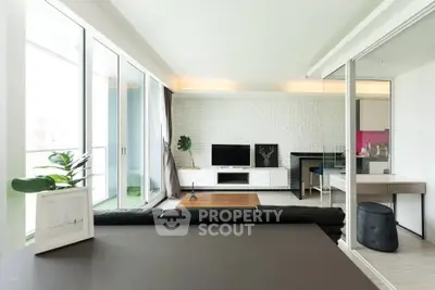 Modern living room with sleek design and open layout, featuring a stylish TV unit and large windows.