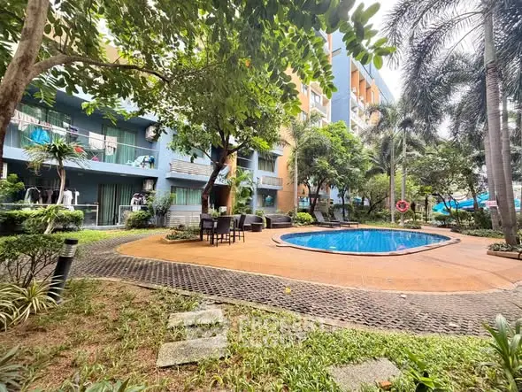Lush garden with pool in modern residential complex, perfect for relaxation and leisure.