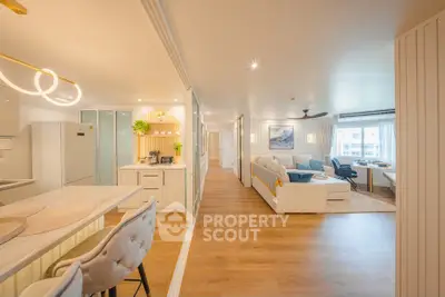 Spacious open-plan living room and kitchen with modern decor and natural light.