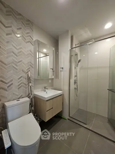 Modern bathroom with sleek design, featuring a glass shower enclosure and stylish vanity.