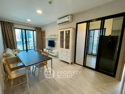 Modern living room with balcony view and stylish furniture in urban apartment.