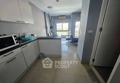 Modern open-layout kitchen with sleek cabinets and bright living area view.