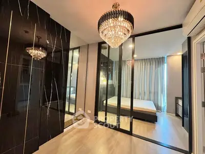 Luxurious bedroom with elegant chandelier and mirrored wardrobe doors