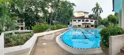 Luxurious residential pool area with lush greenery and elegant architecture