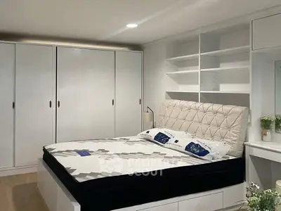 Spacious bedroom with modern design and ample storage in a stylish real estate property.