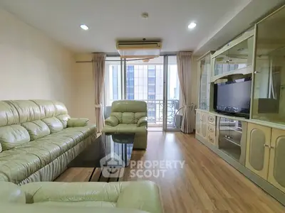 Spacious living room with modern furniture and large windows offering city views.