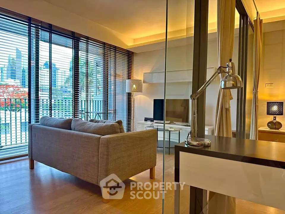 Modern living room with city view, featuring stylish furniture and floor-to-ceiling windows.