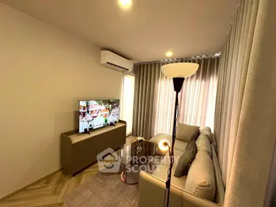 Modern living room with cozy sofa, stylish floor lamp, and wall-mounted TV in a well-lit space.