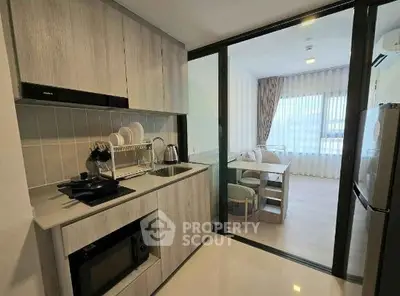 Modern kitchen with sleek cabinetry and open layout leading to dining area