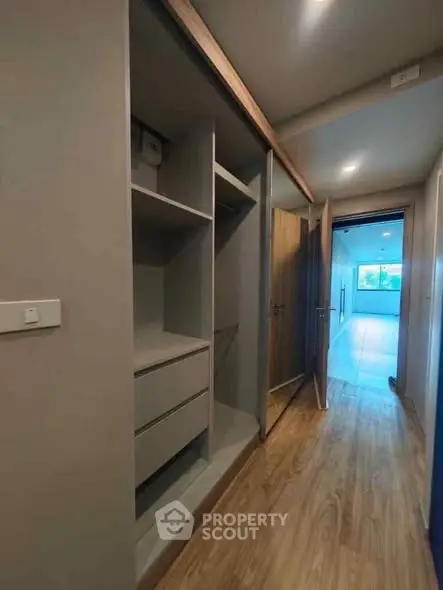Modern hallway with built-in storage leading to a bright living area.