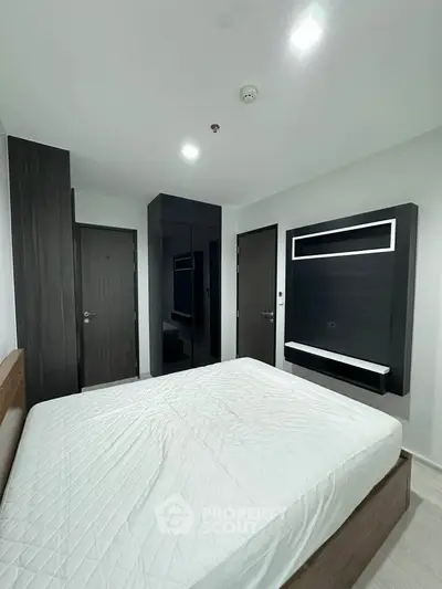 Modern bedroom with sleek design and minimalist decor, featuring a comfortable bed and stylish storage solutions.