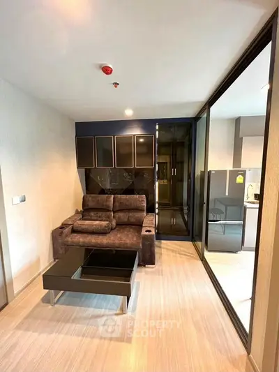 Modern living room with sleek furniture and glass partition in stylish apartment.