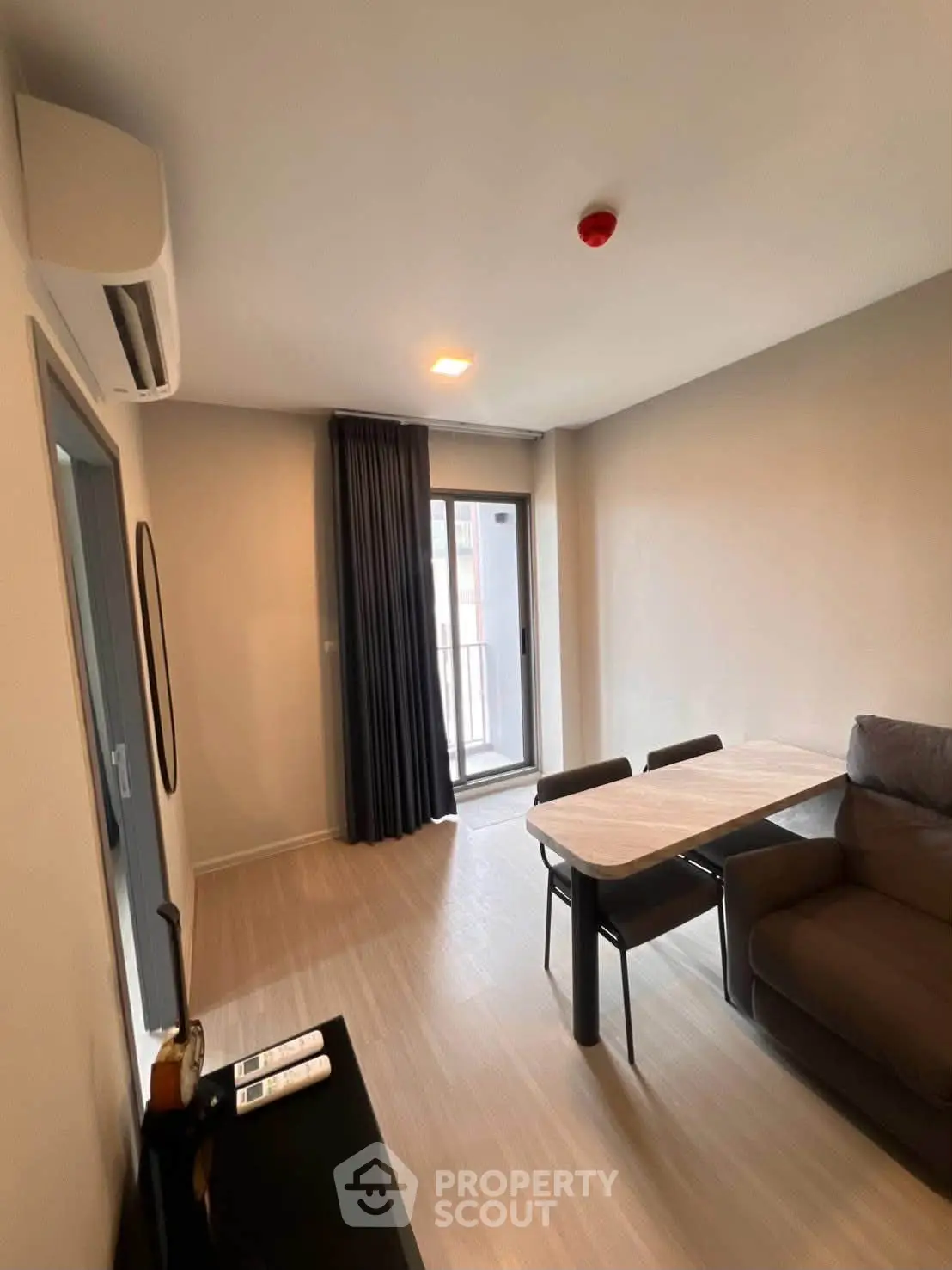Modern living room with sleek furniture and balcony access in a stylish apartment.
