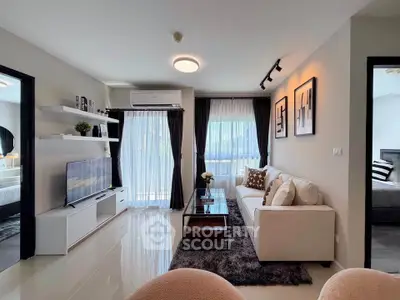 Modern living room with elegant decor, large windows, and cozy seating area in a stylish apartment.
