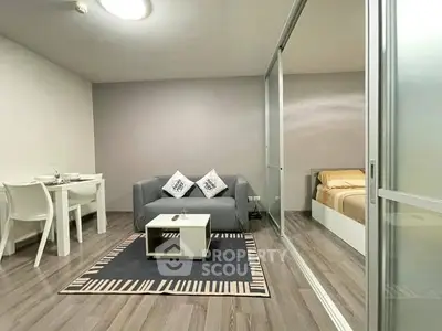 Modern living room with cozy sofa and dining area, adjacent to a stylish bedroom.