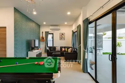 Stylish living room with pool table and modern decor, perfect for entertainment and relaxation.