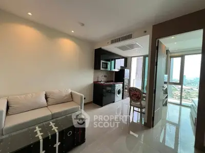 Modern apartment interior with open layout, featuring a cozy living area and sleek kitchen with city views.