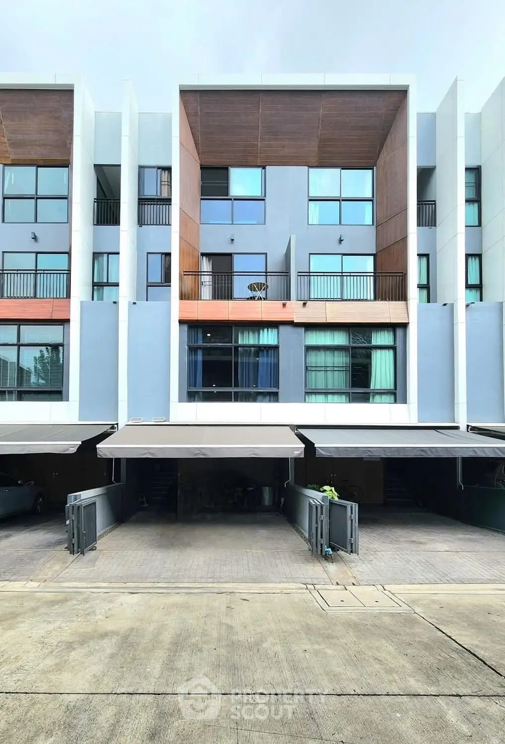 Modern townhouse exterior with multiple balconies and garage spaces