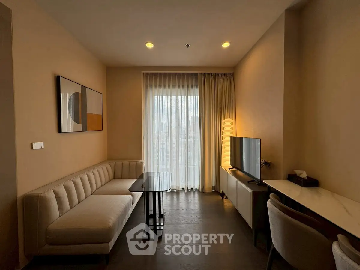 Modern living room with stylish decor and natural light, featuring a cozy sofa and sleek TV setup.