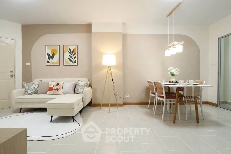 Modern living room with stylish decor and dining area, featuring cozy seating and elegant lighting.
