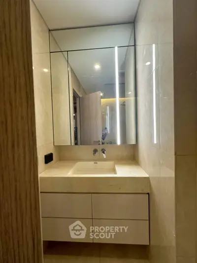 Modern bathroom with sleek vanity and large mirror in luxury apartment.