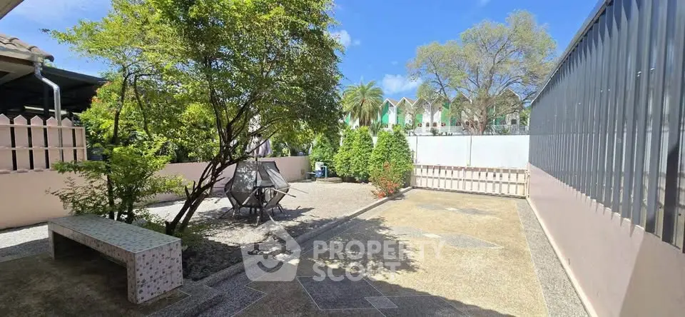 Spacious outdoor garden area with seating and lush greenery, perfect for relaxation and leisure.