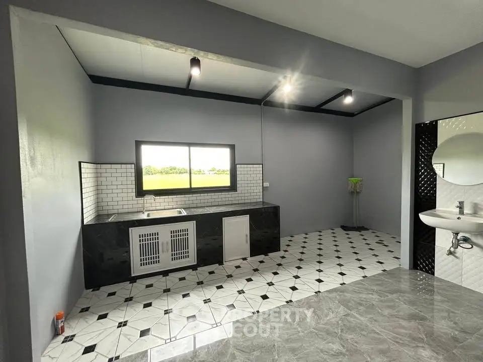 Modern kitchen with sleek black and white design, featuring open layout and stylish flooring.