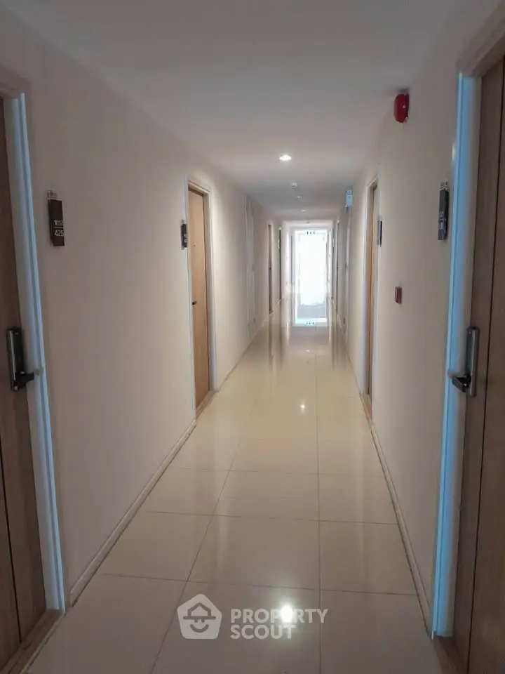 Spacious and well-lit corridor in modern apartment building with sleek design.