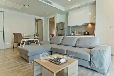 Modern living room with open kitchen and stylish furniture in a contemporary apartment.