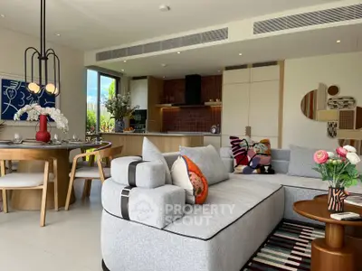Luxurious modern living room with open kitchen, stylish decor, and vibrant artwork.