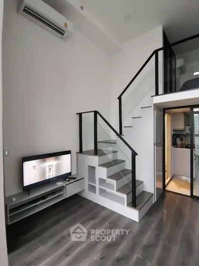 Modern loft apartment with sleek staircase and open kitchen layout