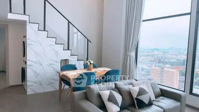 Modern living room with large windows and city view, featuring stylish furniture and elegant decor.