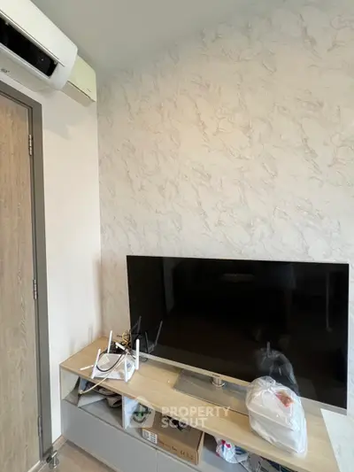 Modern living room with sleek TV setup and air conditioning unit