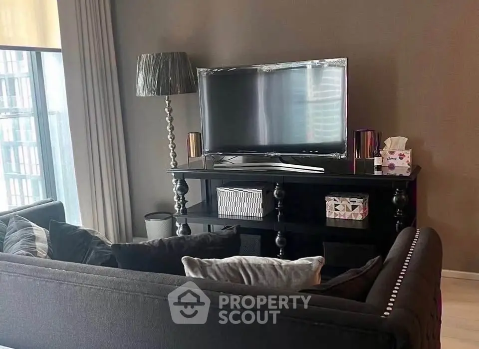 Stylish living room with modern decor and large TV, perfect for relaxation and entertainment.