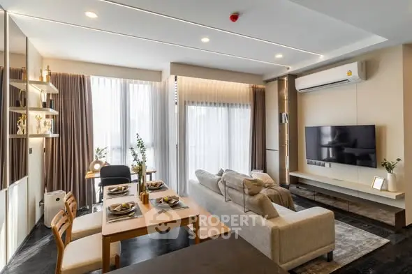 Modern living room with stylish decor, large windows, and cozy seating area in a contemporary apartment.