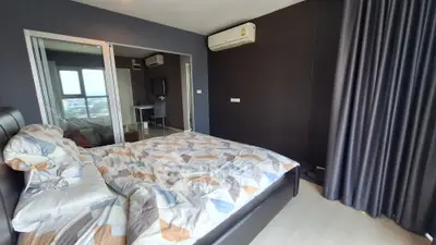 Modern bedroom with stylish decor and large window offering city views