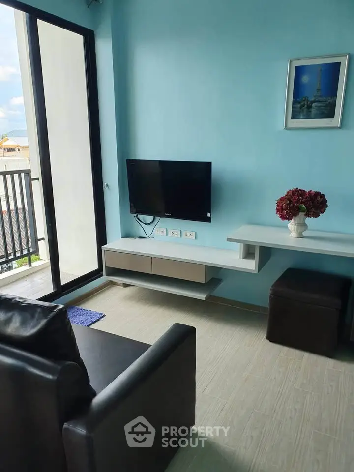 Modern living room with balcony view, sleek TV setup, and stylish decor