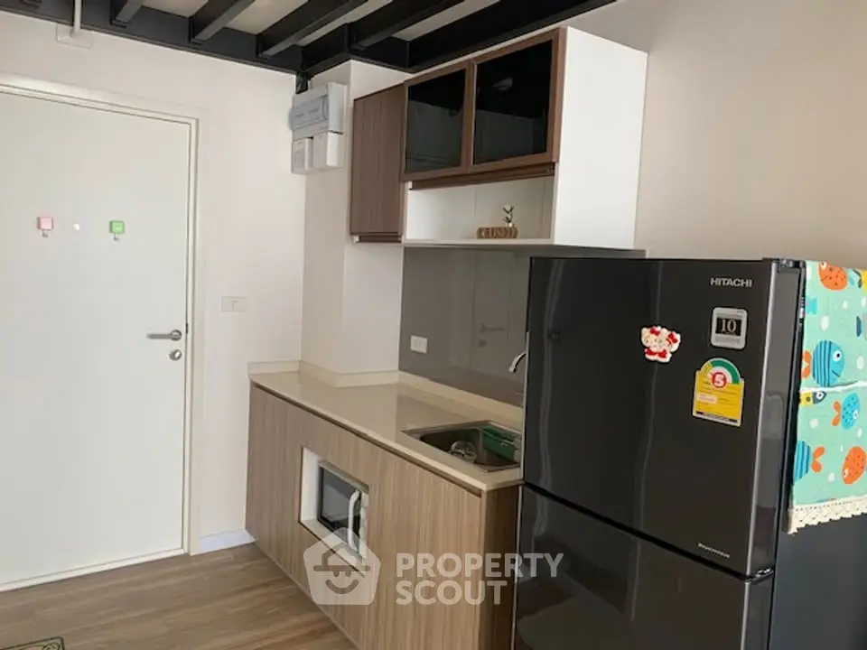 Modern kitchen with sleek cabinetry and stainless steel fridge in a stylish apartment.