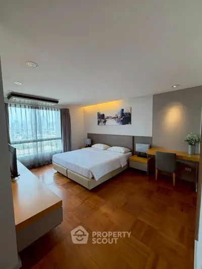 Spacious bedroom with city view, modern furnishings, and elegant decor in a high-rise apartment.