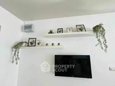 Modern living room with wall-mounted TV and decorative shelves with plants