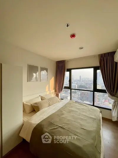 Cozy bedroom with city view, large windows, and elegant decor in urban apartment.