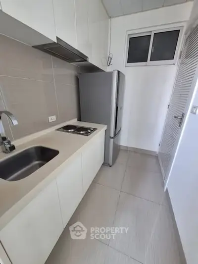 Modern kitchen with sleek design, featuring compact layout and stainless steel appliances.