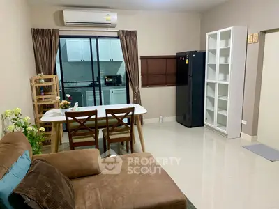 Cozy living room with dining area and modern kitchen in open layout apartment.