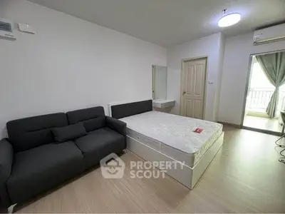 Modern studio apartment with cozy bed and stylish sofa, perfect for urban living.