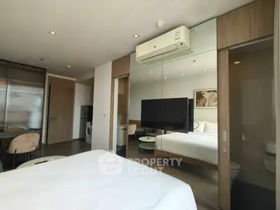 Modern bedroom with sleek design, featuring a wall-mounted TV and air conditioning, perfect for urban living.