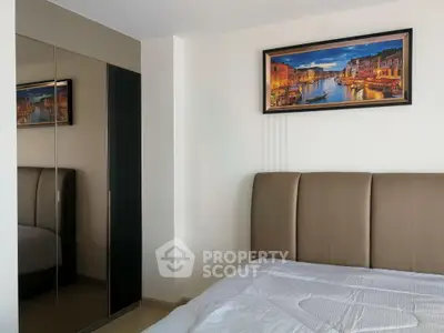 Modern bedroom with stylish decor and large mirrored wardrobe