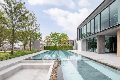 Luxurious modern home with sleek pool and lush garden, perfect for relaxation and entertainment.