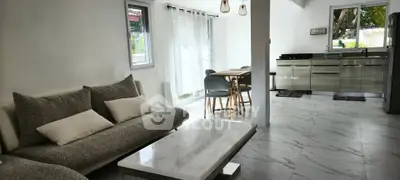 Spacious open-layout living room with modern kitchen and natural light