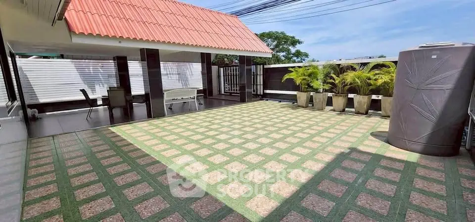 Spacious rooftop terrace with modern design and potted plants, perfect for outdoor relaxation.